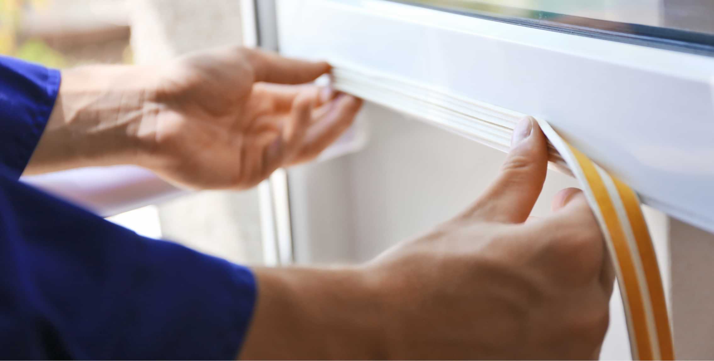 Technician installing weatherstripping on a window frame for improved insulation