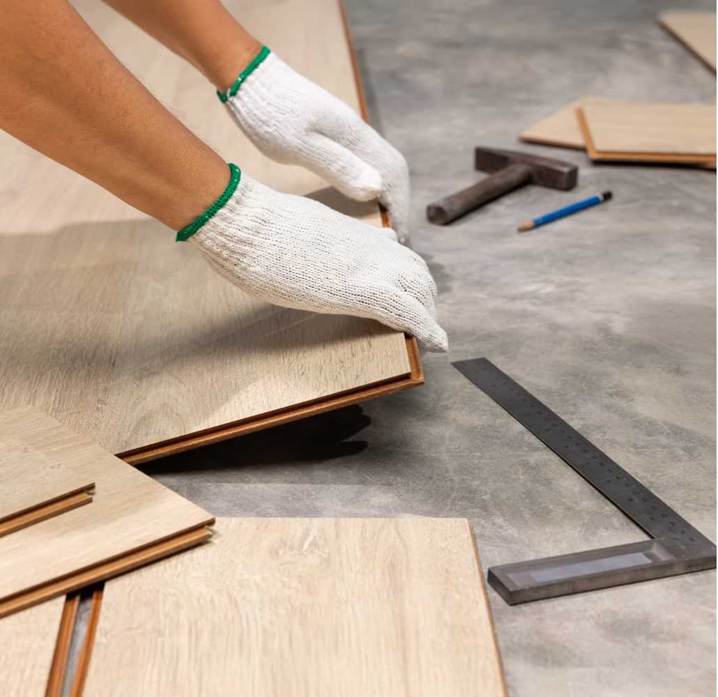 Worker installing wood flooring panels