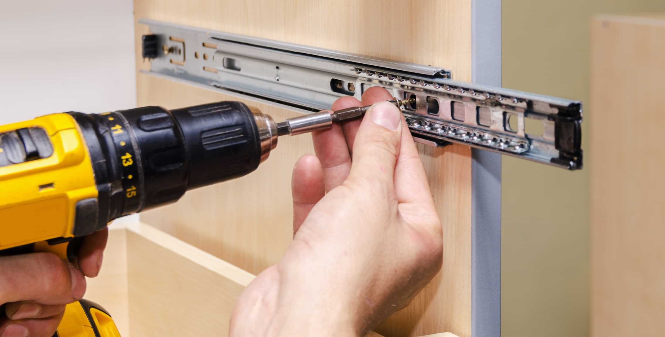 Installing drawer slides with a power drill during furniture assembly