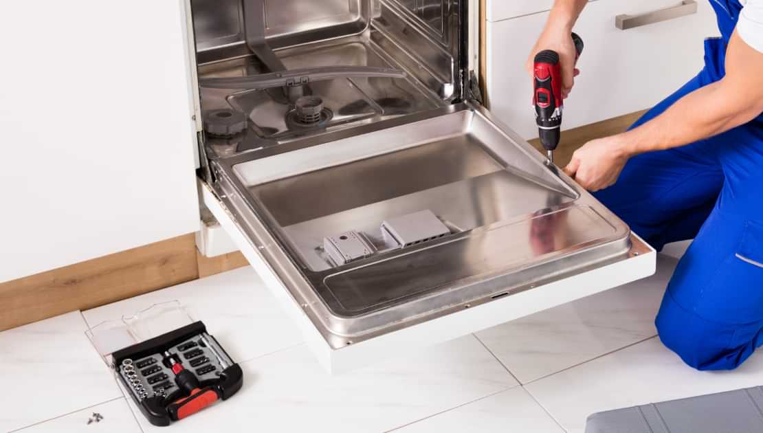 Repairing a dishwasher door with a power drill during home appliance maintenance