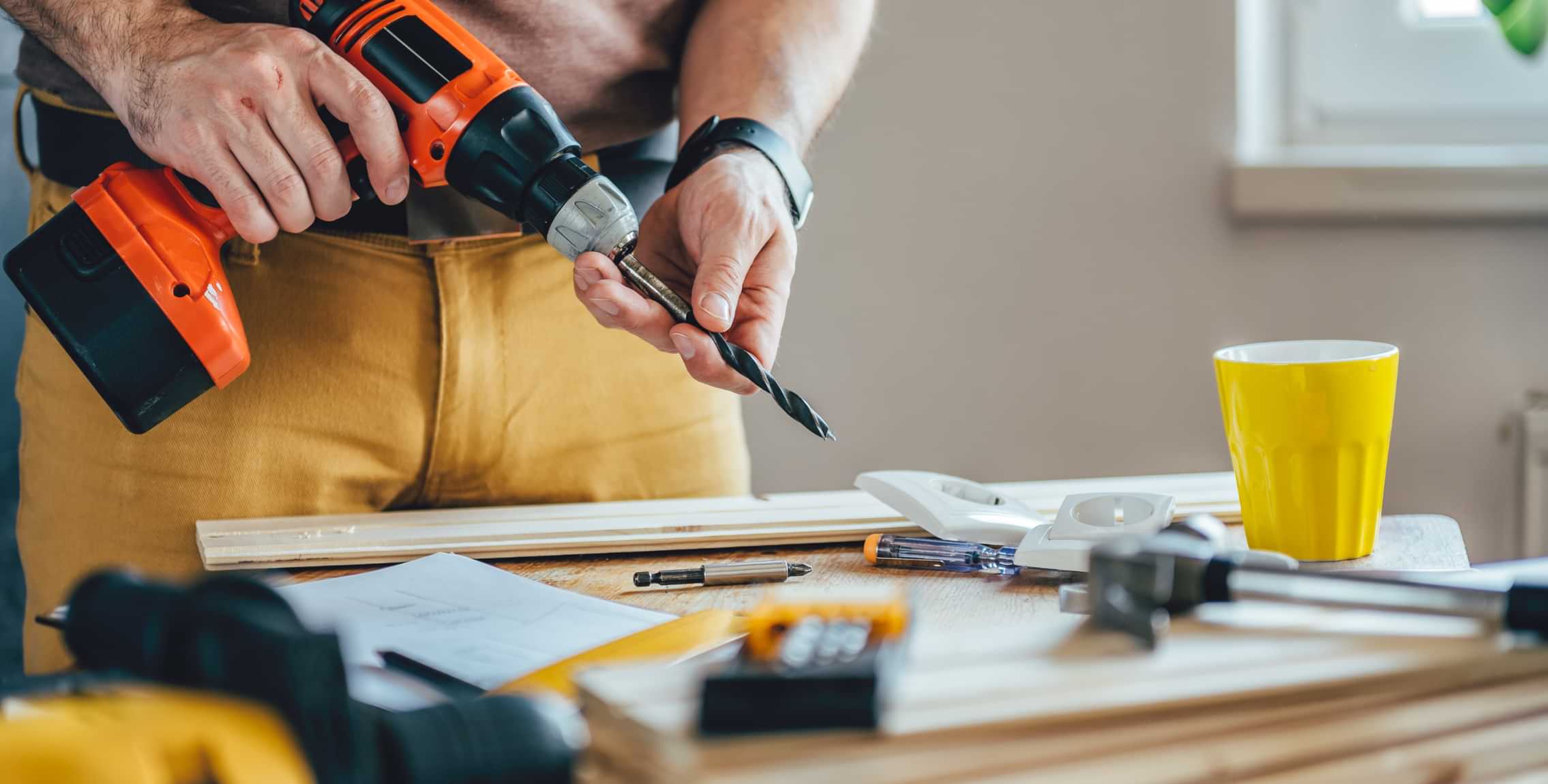 Home repair tools and drill on a wooden floor