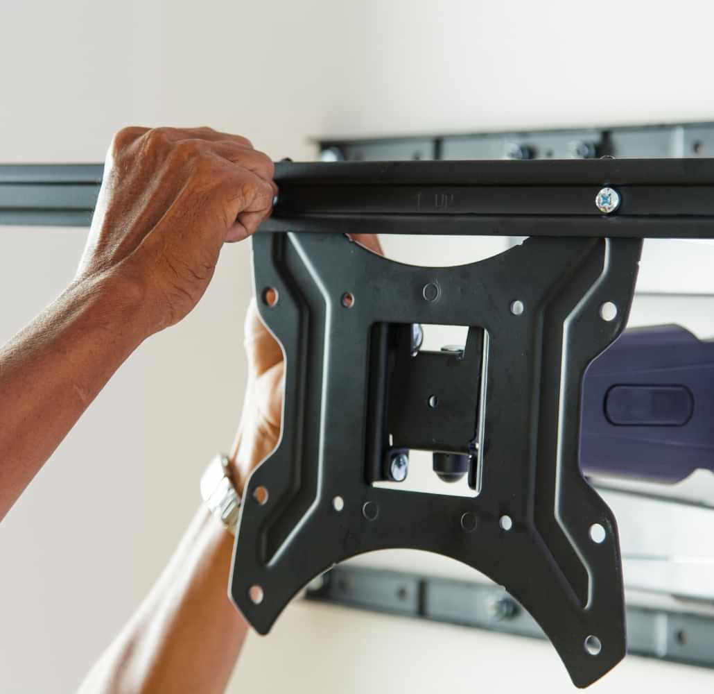 Technician installing a TV wall mount bracket