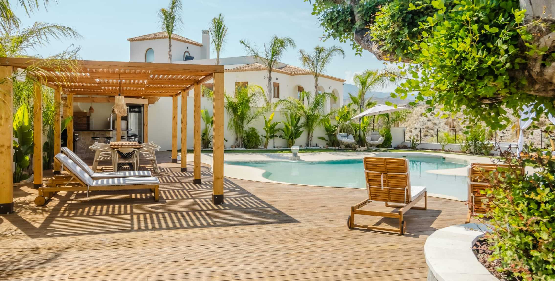 Outdoor wooden deck and pergola beside a swimming pool with lounge chairs