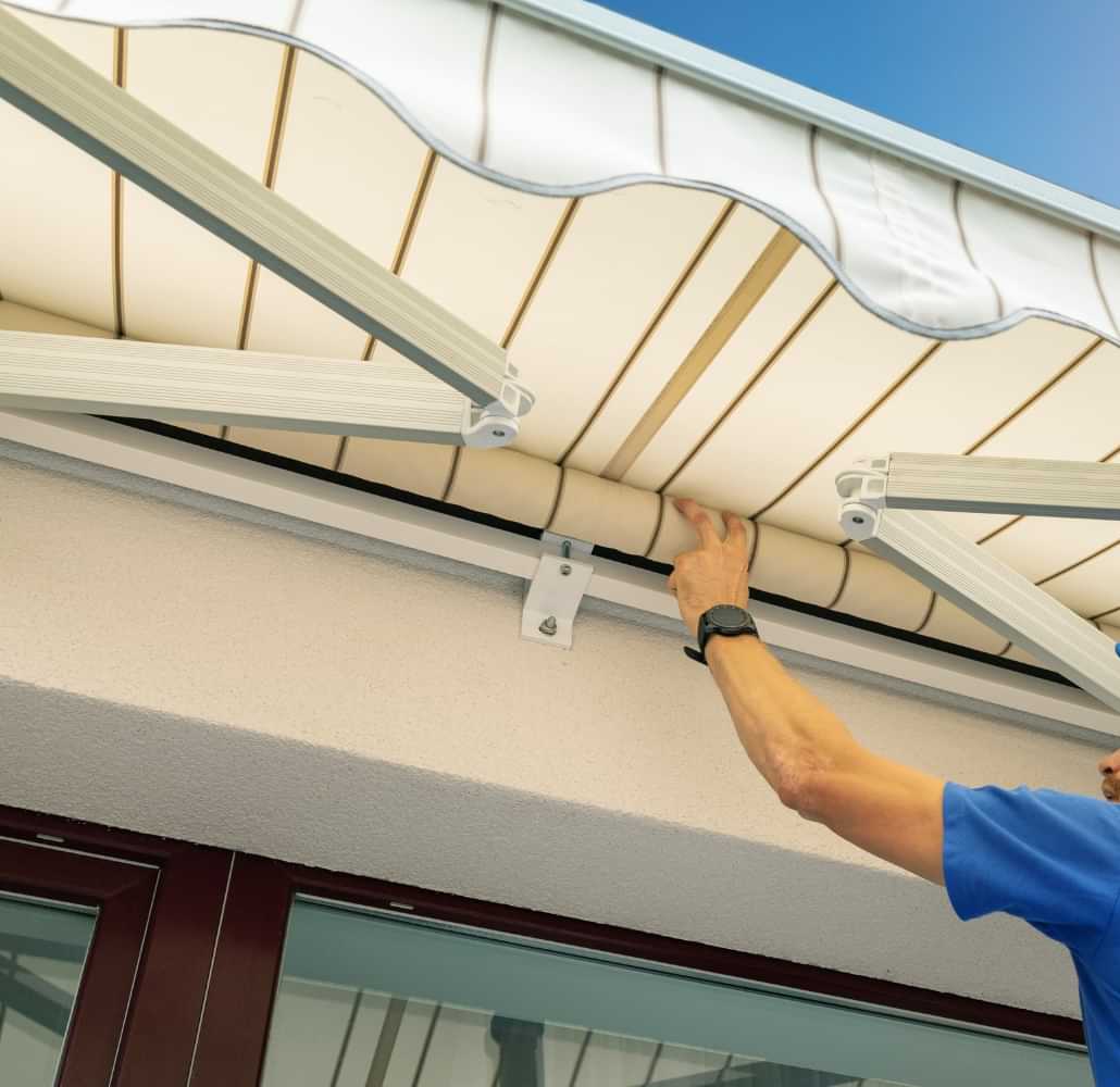 Technician adjusting an outdoor patio awning