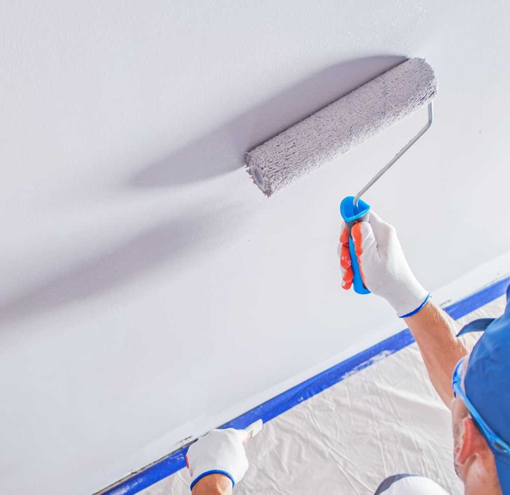 Painter applying fresh paint to an interior wall