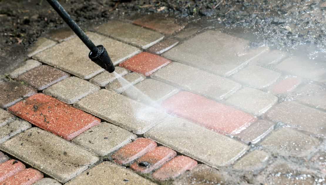 Pressure washing brick paving to remove dirt and grime