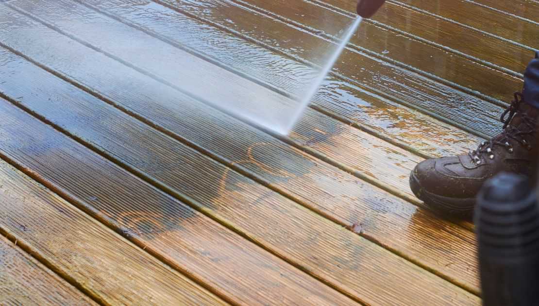 Power washing wooden decking during outdoor cleaning